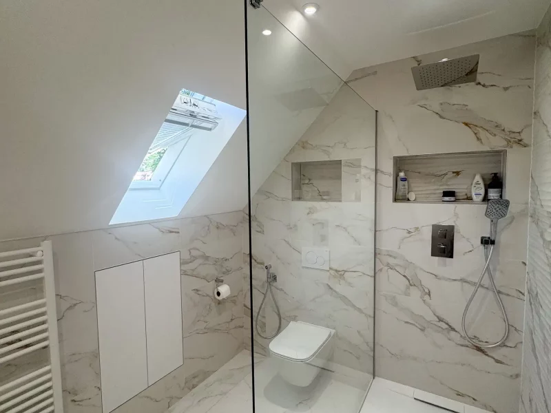 Salle de bains blanc effet marbre élégante à Palaiseau(91) avec douche sous pente verrière et WC suspendu