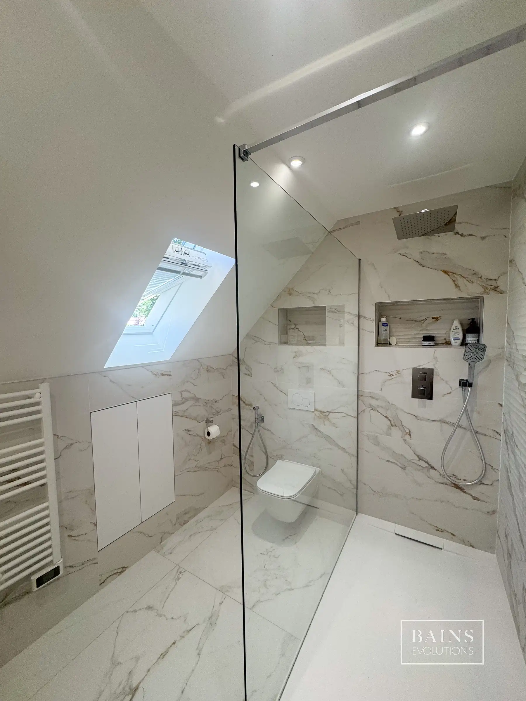 Salle de bains blanc effet marbre élégante à Palaiseau(91) avec douche sous pente verrière et WC suspendu