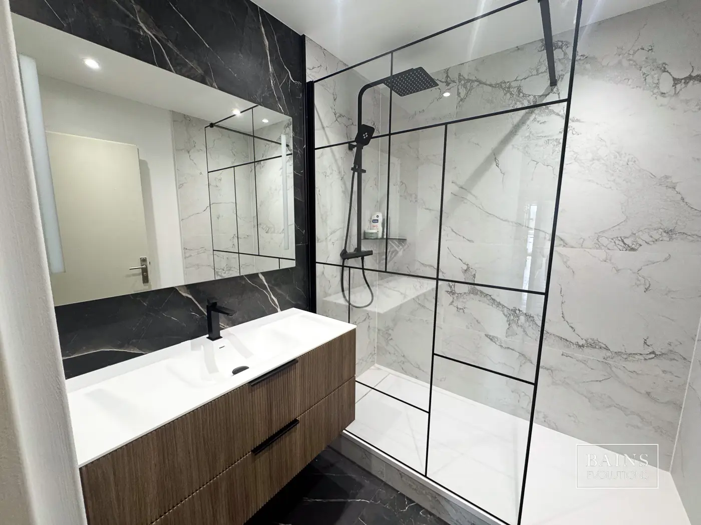 Salle de bains blanc et noir élégante à Sainte-Geneviève-des-Bois avec carrelage effet marbre Museum, meuble vasque Ottofond bois et douche verrière noire