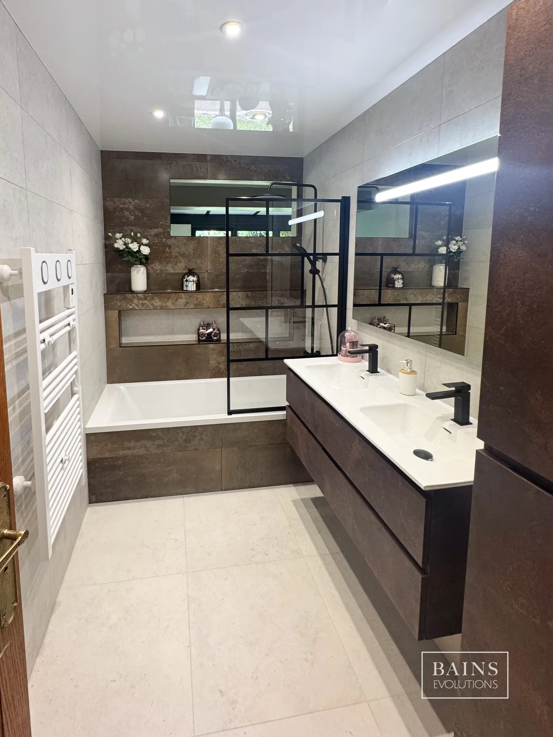 Salle de bains contemporaine à Baulnes avec baignoire, niche intégrée, travertin clair et béton oxydé à Baulnes (91)