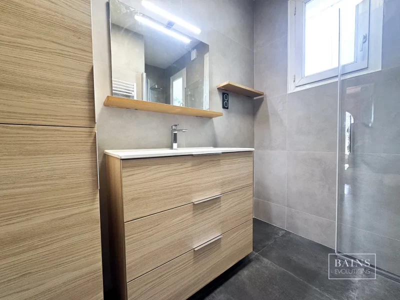 Salle de bains gris minéral et bois clair contemporaine avec meuble vasque suspendu, grand miroir et paroi de douche à Angerville(91)