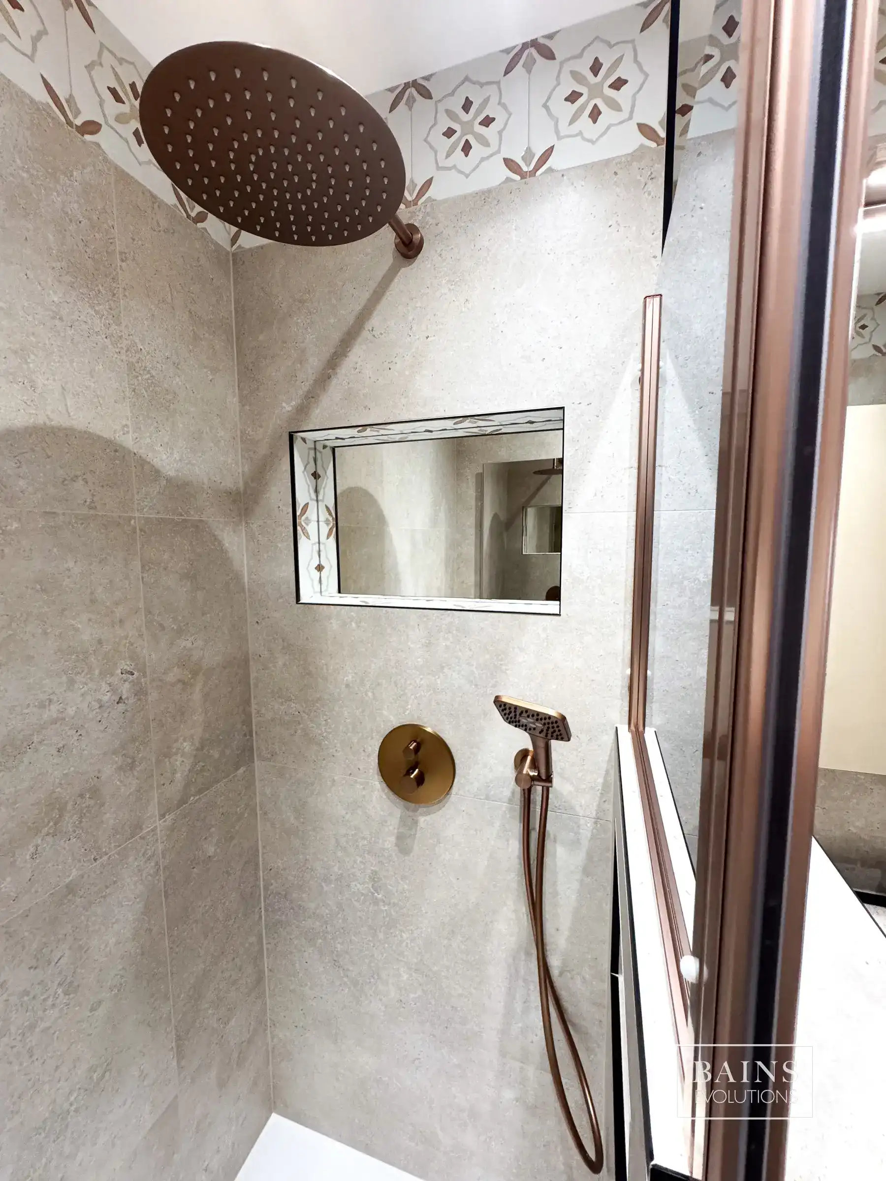 Douche en travertin ivoire avec ciel de pluie cuivre brossé et frise terracotta à Marcoussis (91)